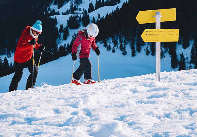 Mand og barn på ski på vej på ad bjerget